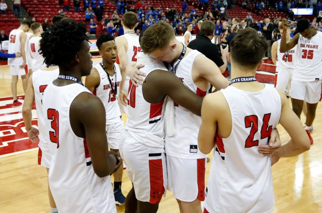 Black and white high school athletes embrace