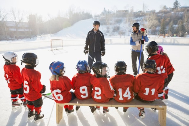 Coaches and ice hockey team on rink