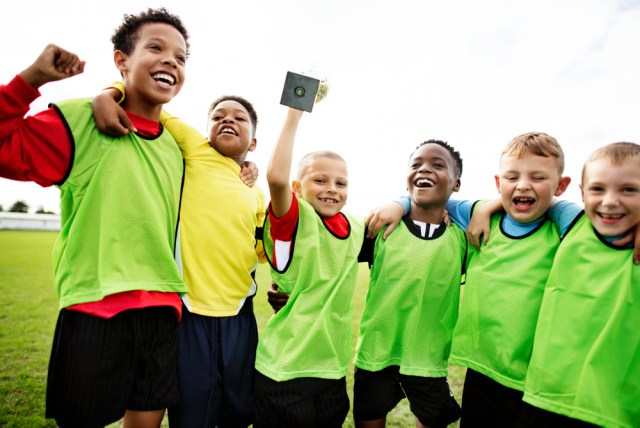 Young kids on the field celebrating their victory