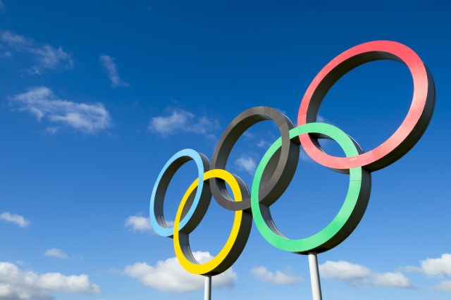 Olympic rings stand under bright blue sky