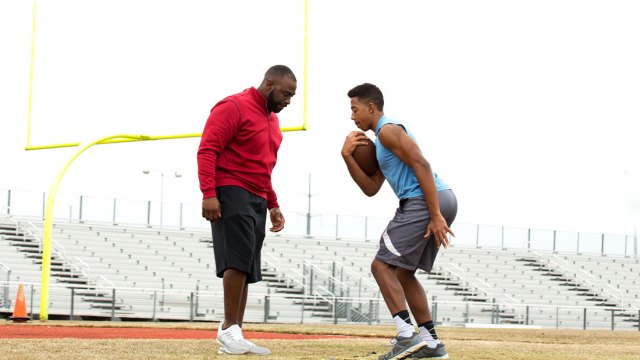 Football coach with athlete